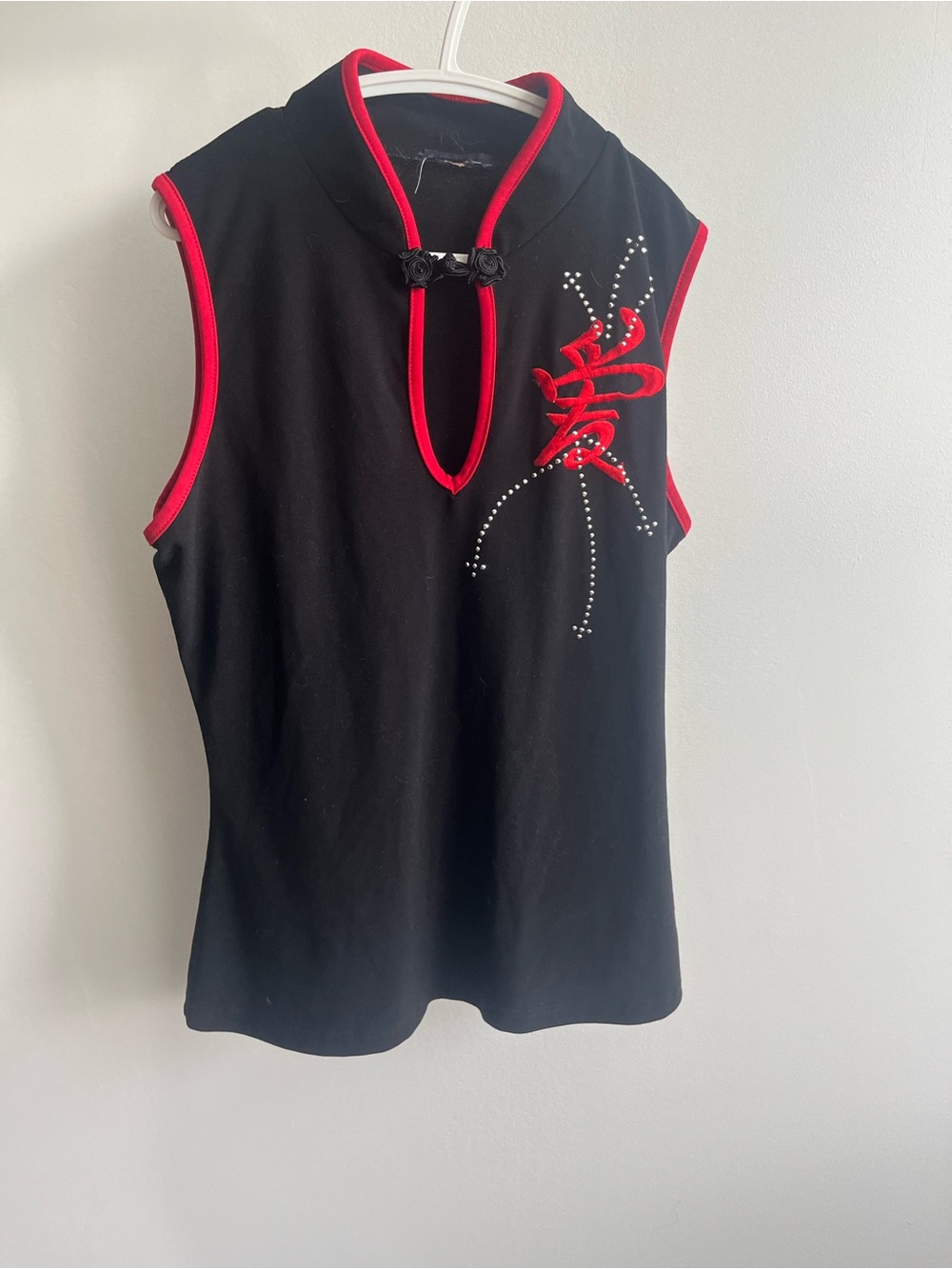 Sleeveless Black Top with Red Trim and Embellished Detail